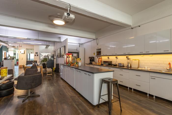 Communal work table beneath framed aerial artwork at Cape Town Office