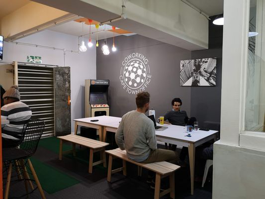 The dining area and arcade machine at Cape Town Office, 2018